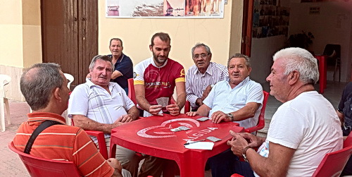 ExperiencePlus! tour leader Enrico Dal Monte stops to join a card game in Sicily.